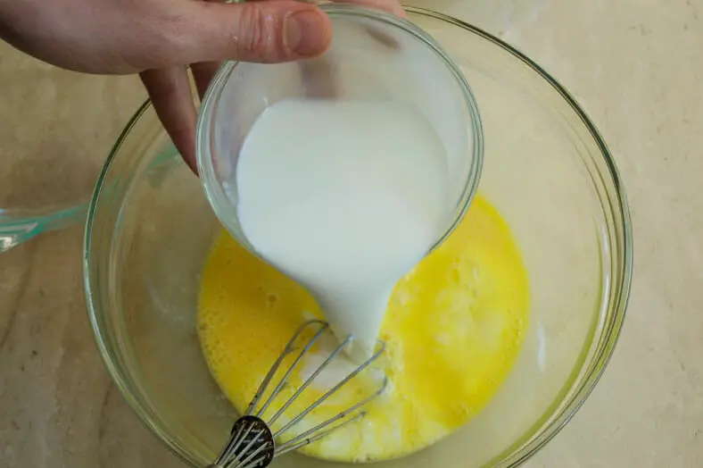 Mixing the nalysnyky (Ukranian crepe) batter ingredients together. Here the heavy whipping cream is being poured and folded into the beaten eggs
