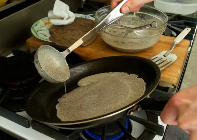 Pouring the crepe batter into a hot pan