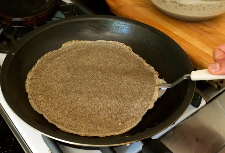 Flipping nearly cooked crepe on one of the sides 