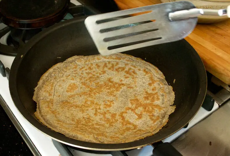 Flipping the nalysnyky (Ukranian crepe) to cook briefly on the other side 