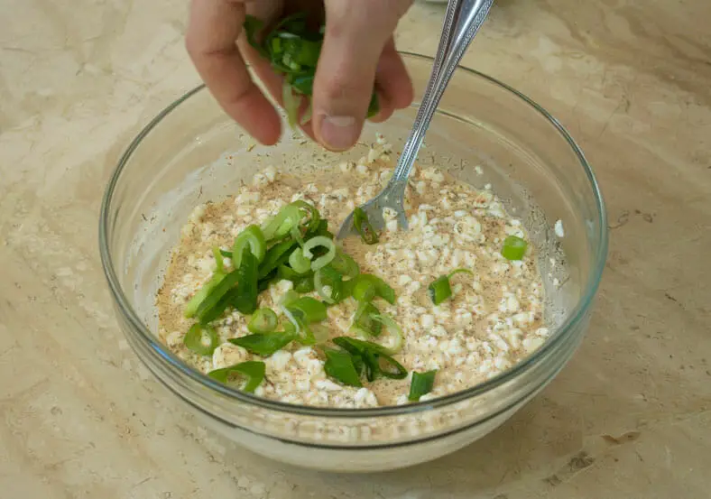 Adding green spring onion on the cheese mixture
