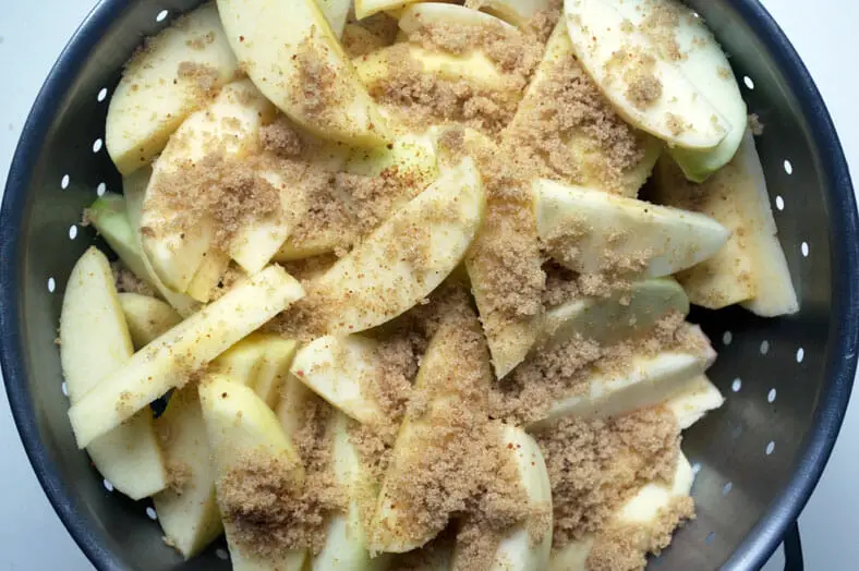 Seasoning apples with sugar and spices for pie
