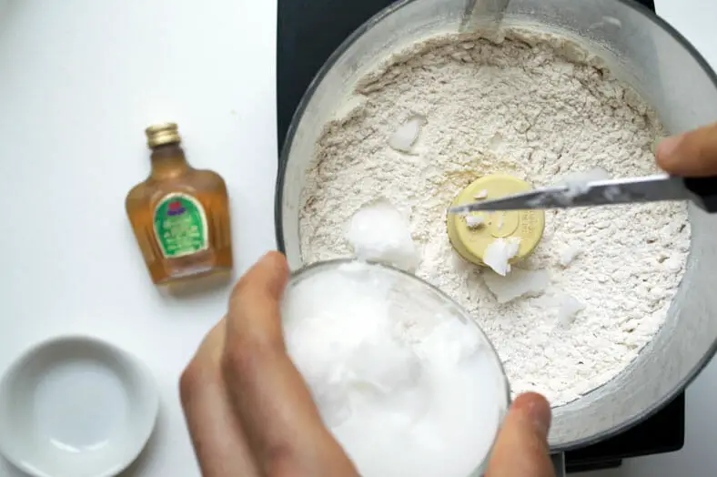 Mixing flour with coconut oil for the dough