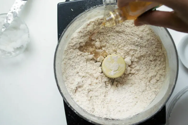 Mixing apple liquor with flour and coconut oil for the dough