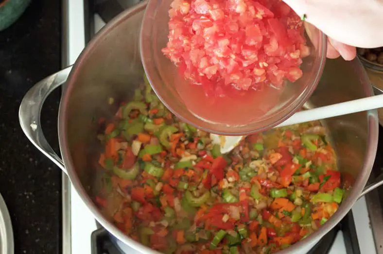 Adding diced tomatoes to pan