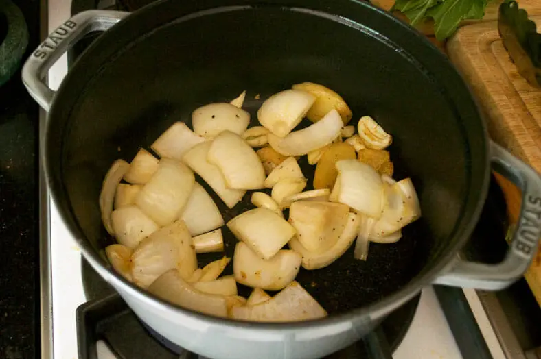 Add onions to mashed garlic and ginger in pan