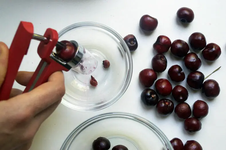 Pitting cherries in a bowl