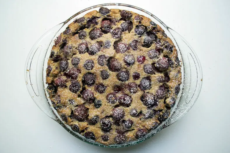 The final baked French cherry tart clafoutis topped with powdered sugar