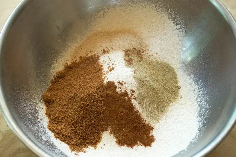 Mixing wheat flour, cinnamon, coconut sugar, cardamom, and salt