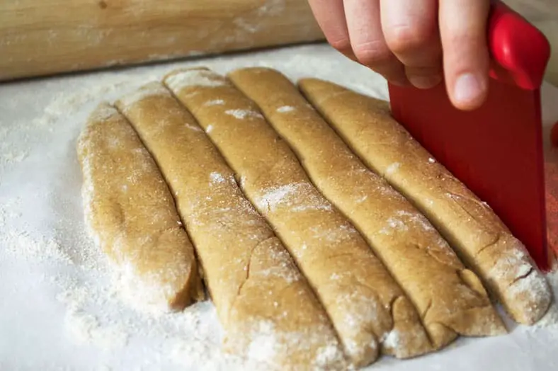 Slicing dough into long stripes