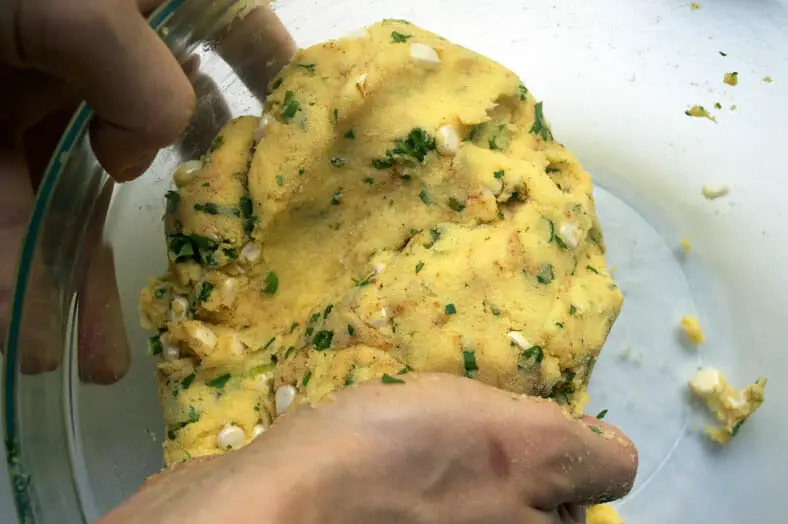 Using hands to mix and well distribute the different ingredients in the dough