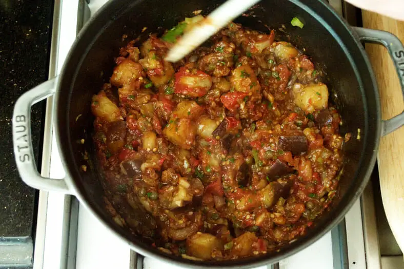 To make caponata, a classic Sicilian dish of stewed aubergines or eggplant, saute and mix all the ingredients together. Let the entire caponata mixture simmer together over low heat for at least 10 minutes.