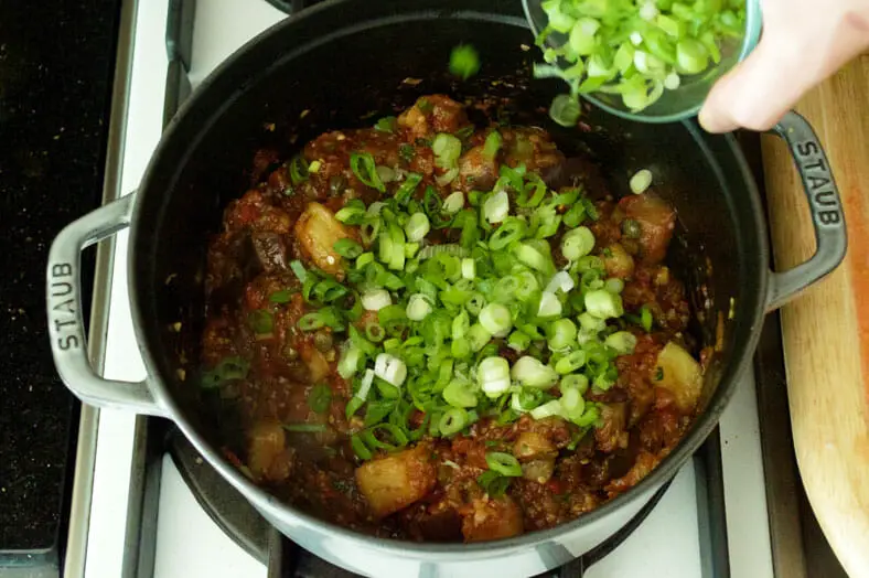 Once mixture is fully simmered, add in chopped scallions and an extra dollop of olive oil into your pot