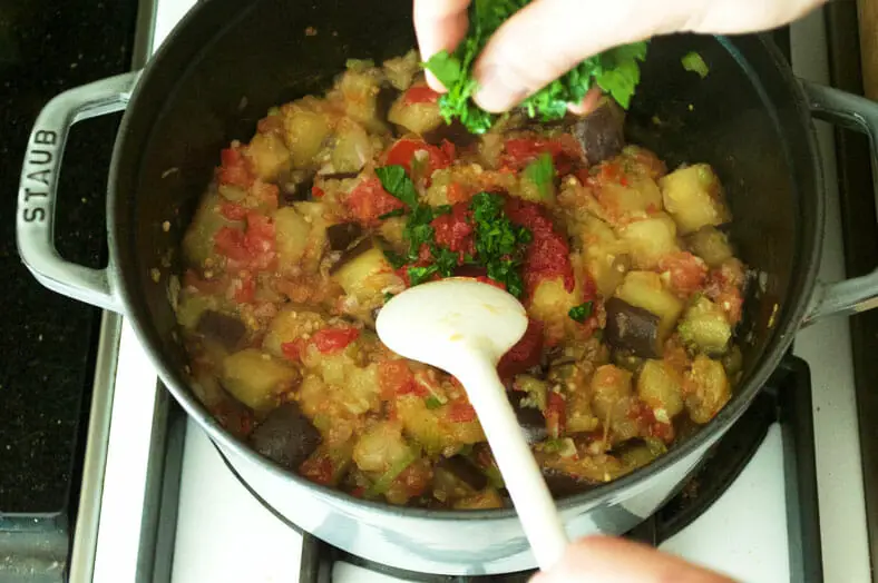 Add peeled and diced tomato, and parsley to the eggplant