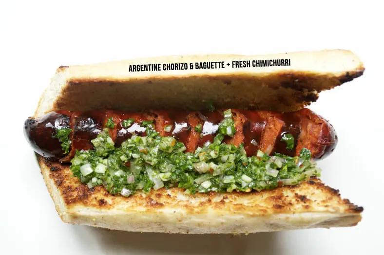 Choripan - Argentine grilled chorizo sausage inside a toasted baguette topped with a heaping dollop of chimichurri