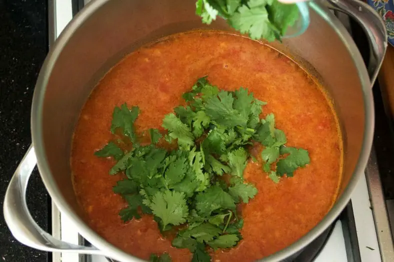 To make Encebollado, a spicy tuna and onion stew, widely regarded as the national dish of Ecuador, start by frying your diced onions, tomatoes, paprika, cumin and cayenne. After those ingredients simmer together, add cilantro and then your tuna
