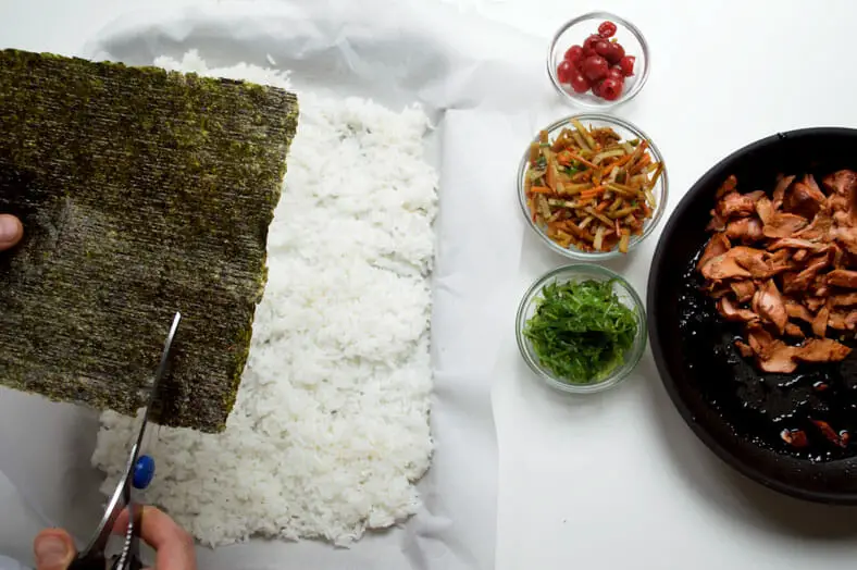 With your onigiri fillings made, lay out your other ingredients in an assembly line of sorts and cut some sheets of seaweed to wrap around the shaped onigiri