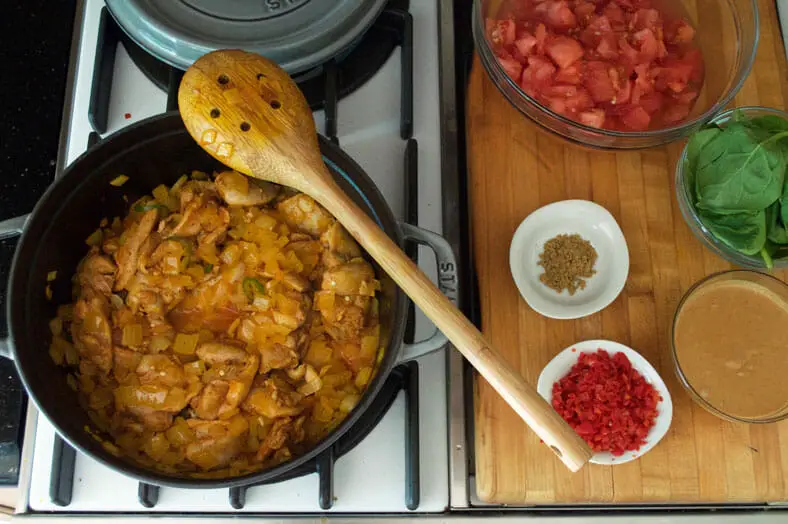 The next step is to move your onions to one side, then add your chicken (along with the lemon juice and green chilis) onto the bottom of the pan and on direct heat. After several seconds of initial searing, mix your chicken and onions around, and cook them together for 2-3 minutes.