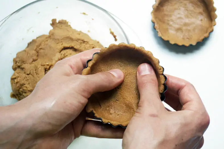 Pressing the dough to perfectly take shape of tart tin
