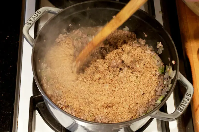 Adding breadcrumbs into the pot to thicken the mixture