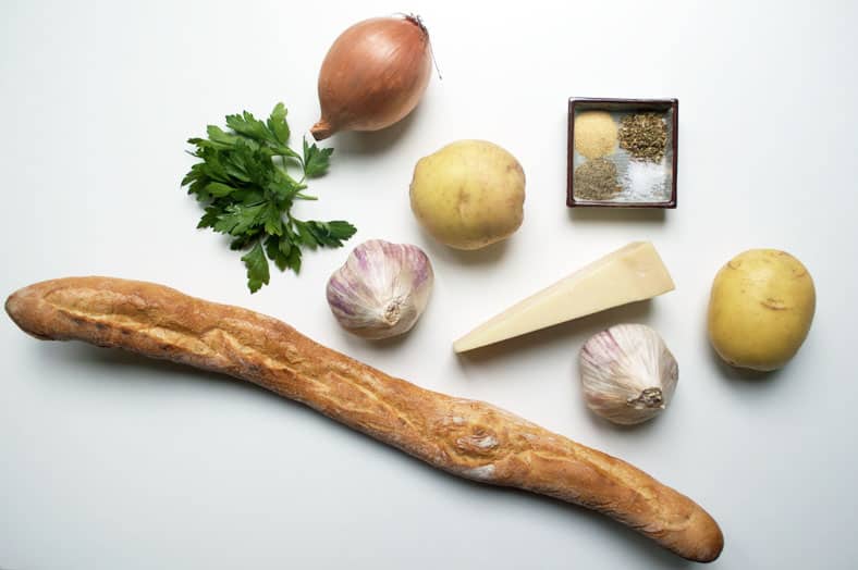 View of ingredients - garlic, potato, onion, parmesan cheese, baguette loaf