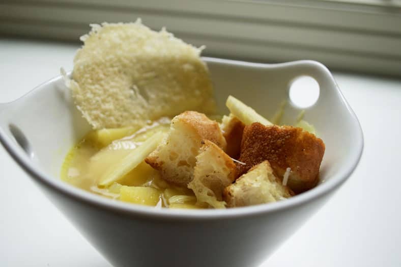Serving bowl with soup, croutons and cheese.