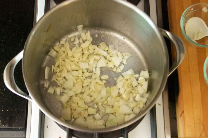 Start by bashing the cloves and then adding them to a pot with some simmering butter, after a few minutes you'll then add your diced onion.