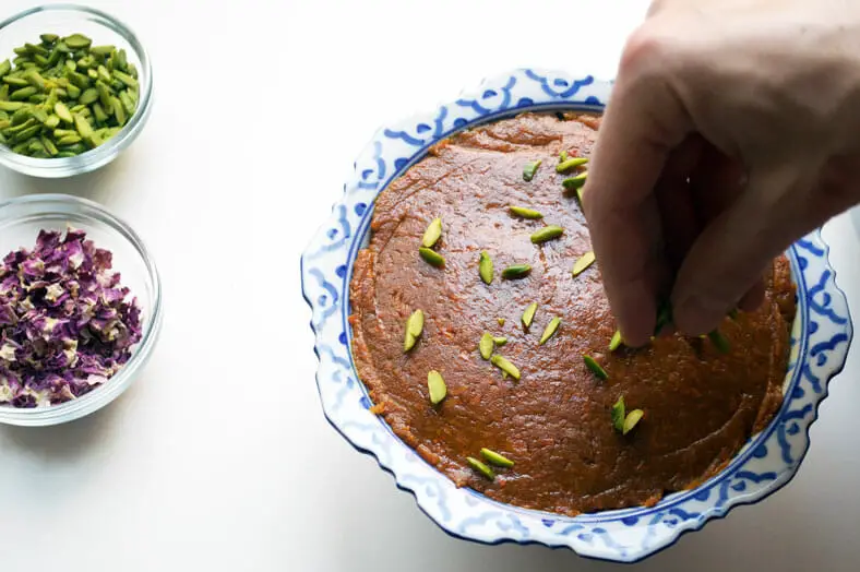 One great trick is to sprinkle crumbled pistachios on top of your halva ye havij (Persian sweet carrot confection), which will cake into the dessert as it cools