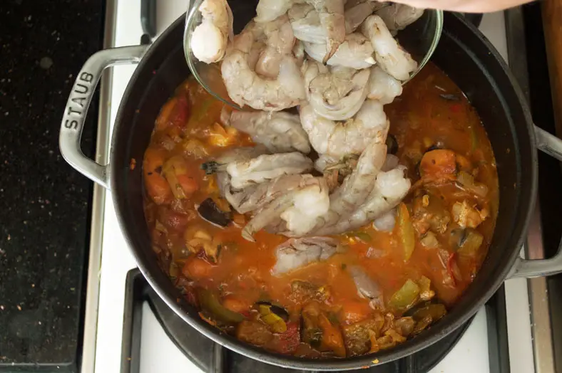 Finally, to give the stew some added seafood flavor, we'll add in some deveined shrimp into the pot for the final minutes. It's important to note, though, that they are not peeled, since the shells offer extra flavor to the broth!