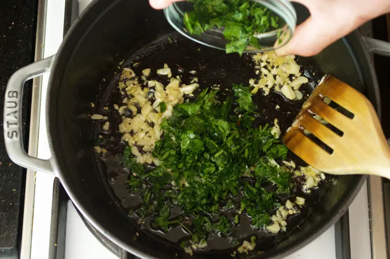 Adding chopped parsley into the pot