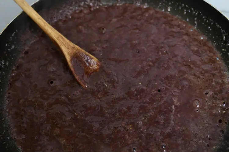 Adding black bean puree to onions in pan