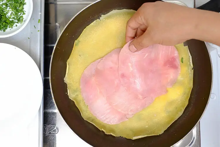 Covering the cream cheese with ham pieces