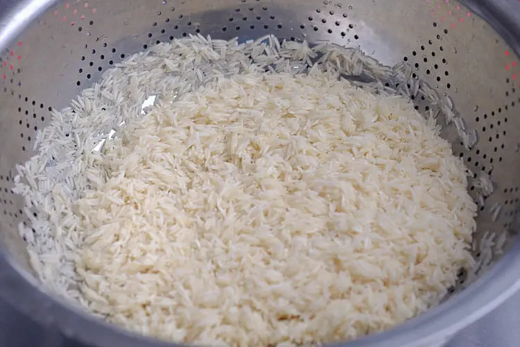 Draining water from rice and letting it air dry for 10 minutes