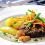 Beef steak, fried potatoes and stew in serving plate