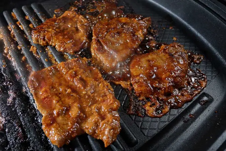 Cooking marinated beef on the grill pan