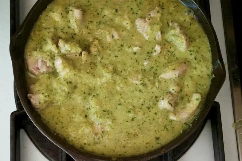 Letting chicken and green sauce cook till thick consistency