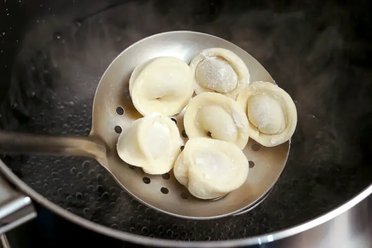 Placing dumplings in the boiling water or vegetable broth