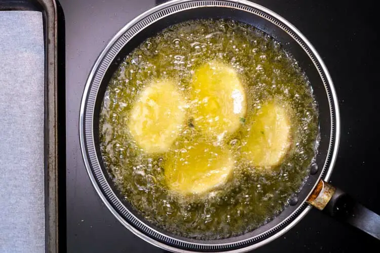Deep frying potatoes into hot oil in pan