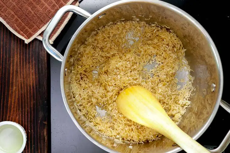 Adding rice and vermicelli to the butter in pot