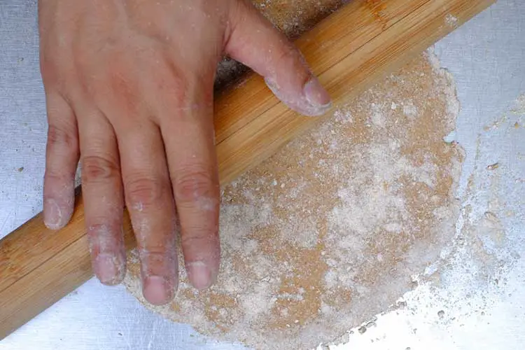 Rolling of dough ball into large circle with rolling pin