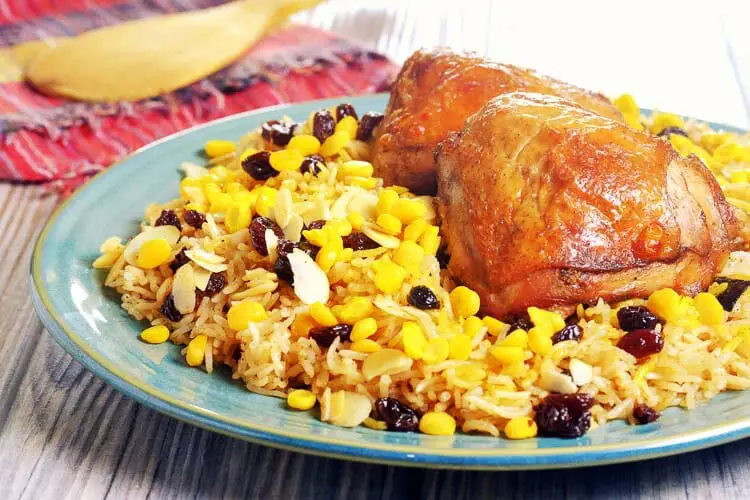 Baked chicken and saffron infused rice with raisins and almonds toppings