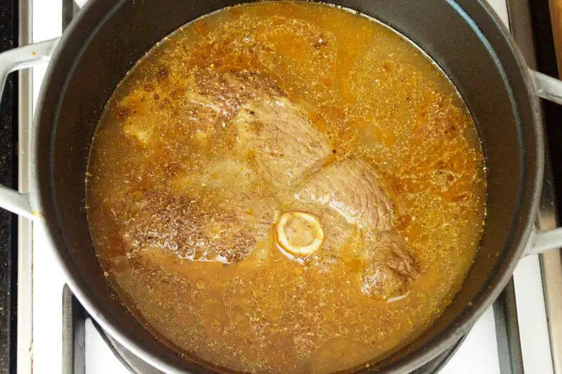 Adding water to the cooked lamb