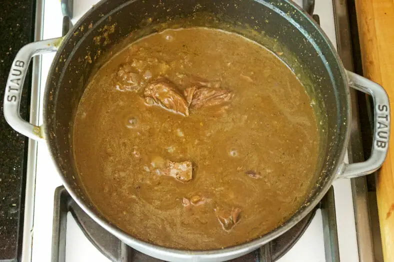 Letting lamb and onion mixture cook till gravy thickens