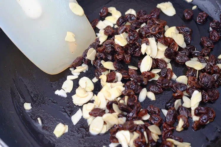 Sautéing almonds and raisins in pan