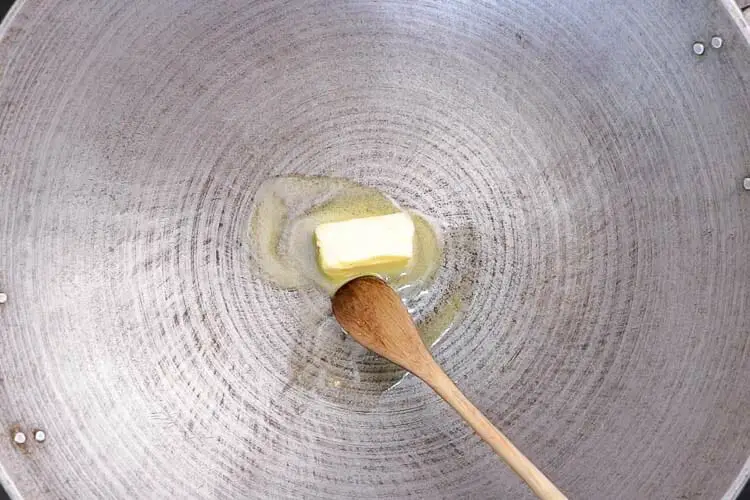 Adding butter to the wok on medium heat
