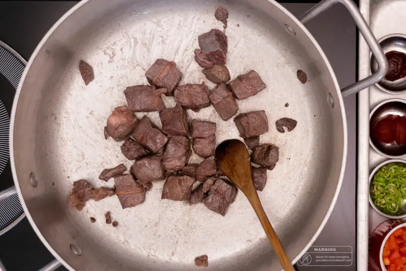Searing lamb pieces in pan