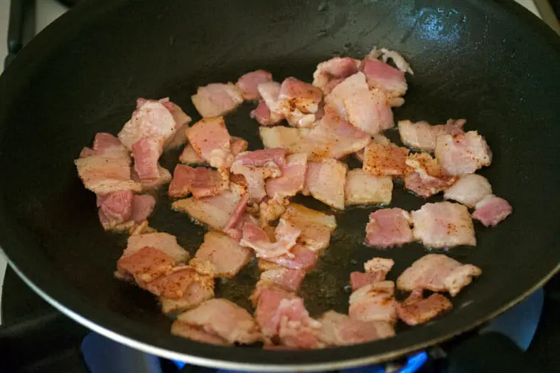 Cooking bacon in the pan for garnishing