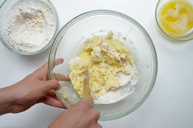 Adding flour to potatoes for dumplings
