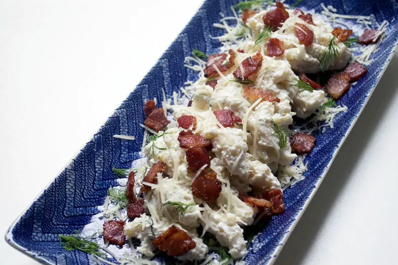 Cheesy potato dumplings with bacon on a serving plate