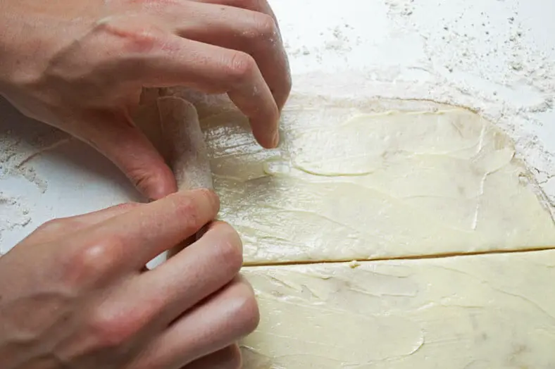 Rolling half cut dough into cylinder shape